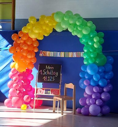 Herzlich Willkommen, liebe Erstklässler 2025! Luftballonbogen von der Sonne beleuchtet